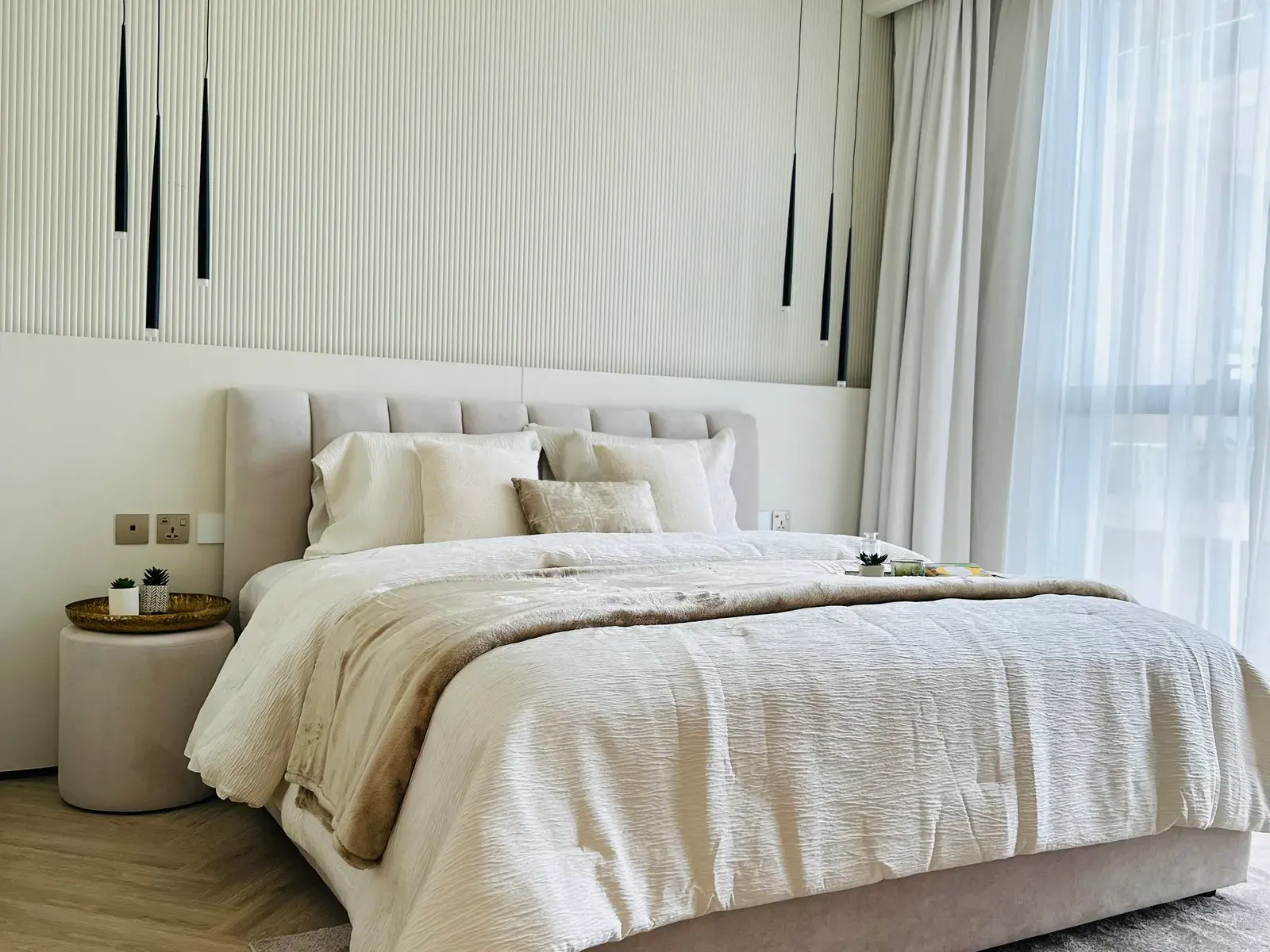 Guest bedroom with a fluted wall panel behind an upholstered headboard