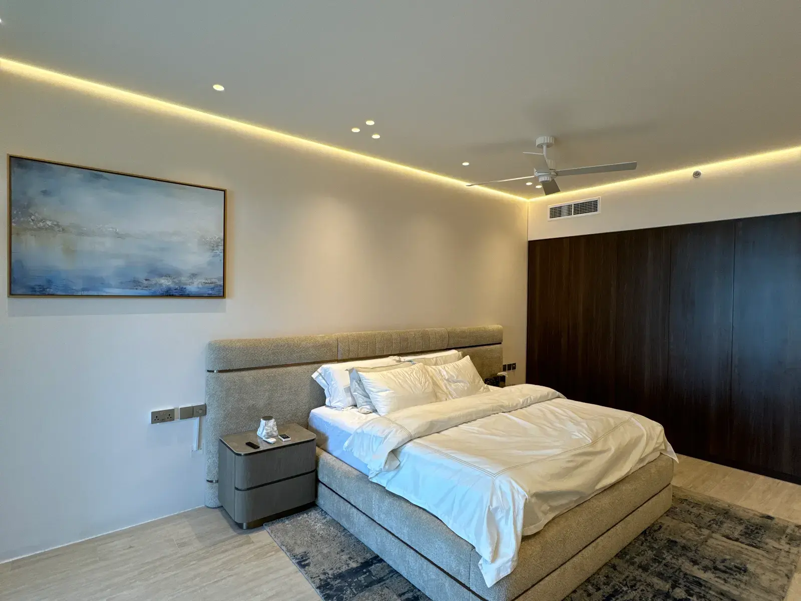 Principal bedroom with a full-height walnut headboard wall