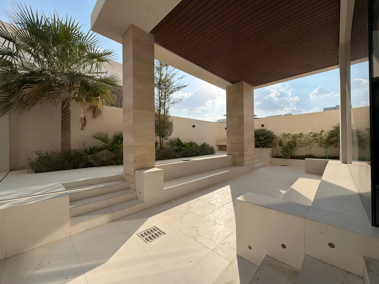 Shaded travertine courtyard with slatted timber soffit at a Halo villa in Nad Al Sheba
