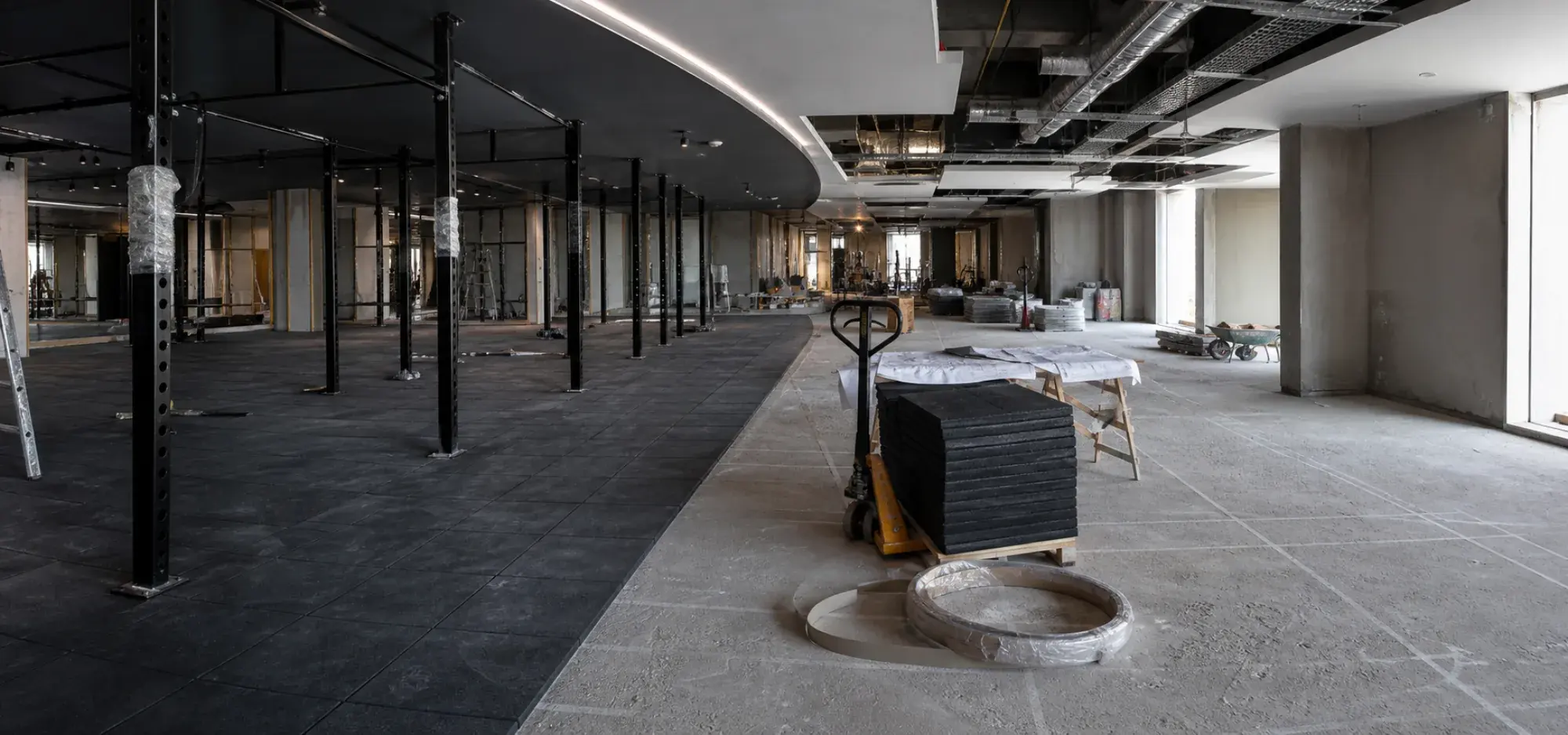 Gym fit-out in progress in Dubai with the strength floor set out and services still exposed