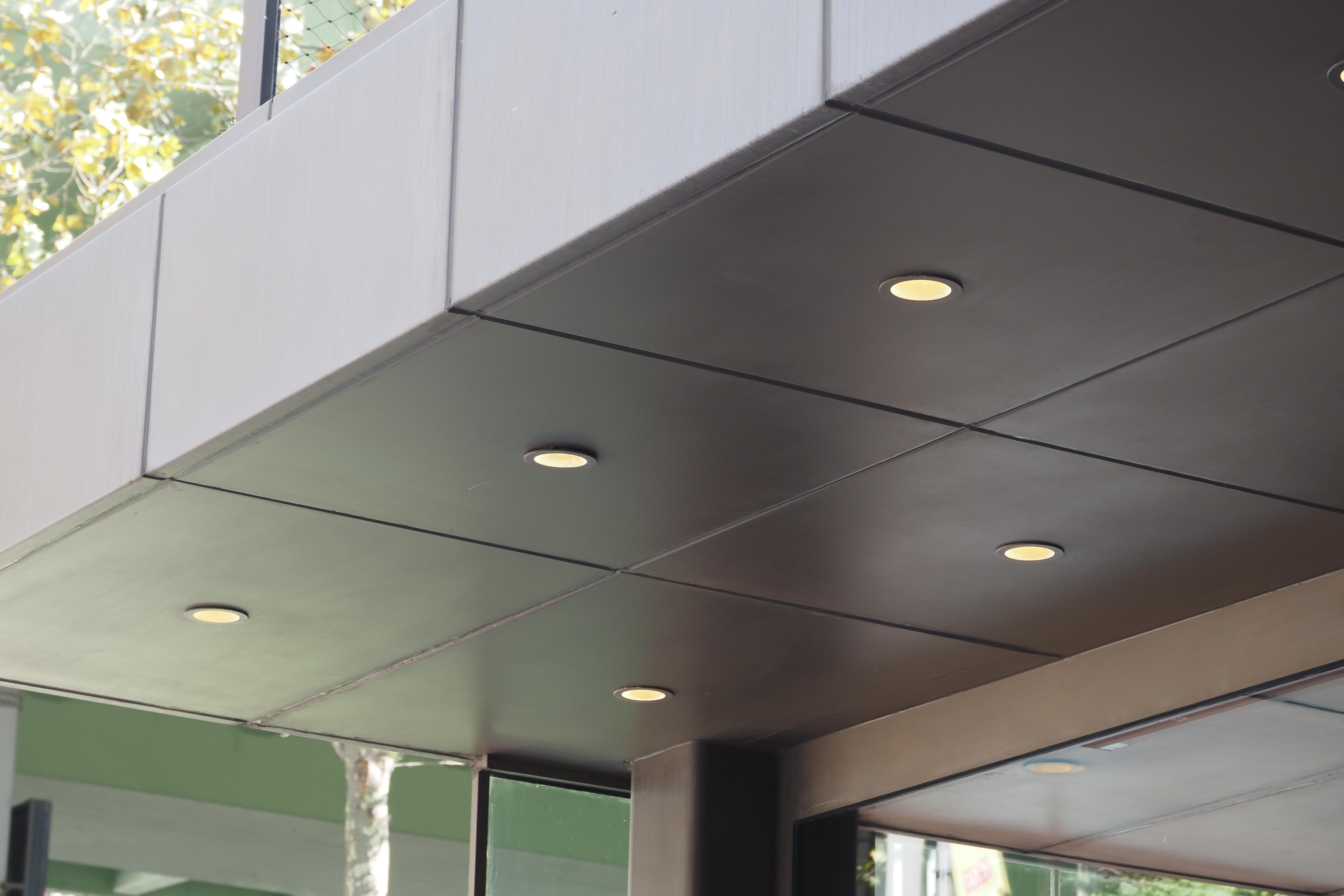 Dark gypsum bulkhead with recessed downlights over a glazed elevation in a Dubai interior