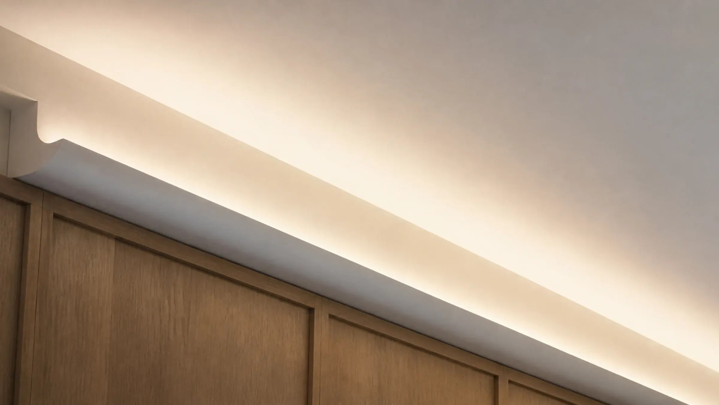Concealed cove lighting detail in a Dubai villa, the LED hidden behind a plaster return lip and washing light across the ceiling