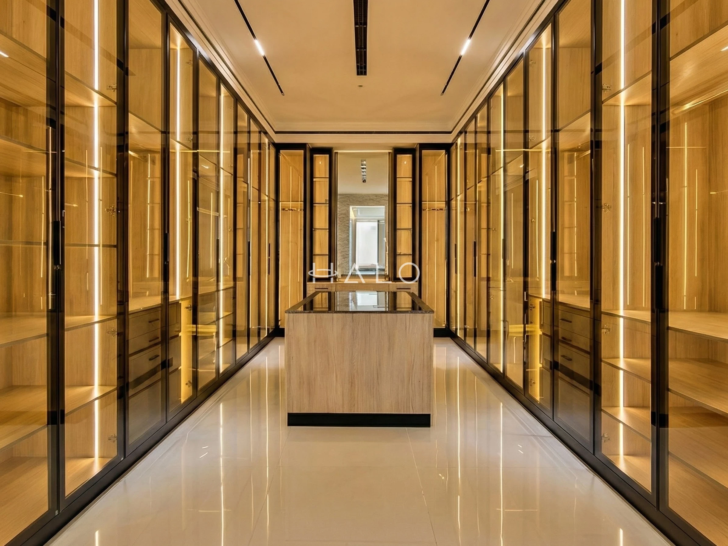 Walk-in wardrobe with lit open shelving and glass-fronted cabinetry