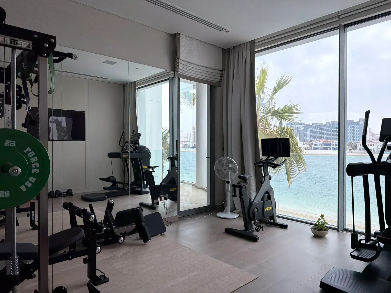 Home gym with full-height glazing looking out to the sea
