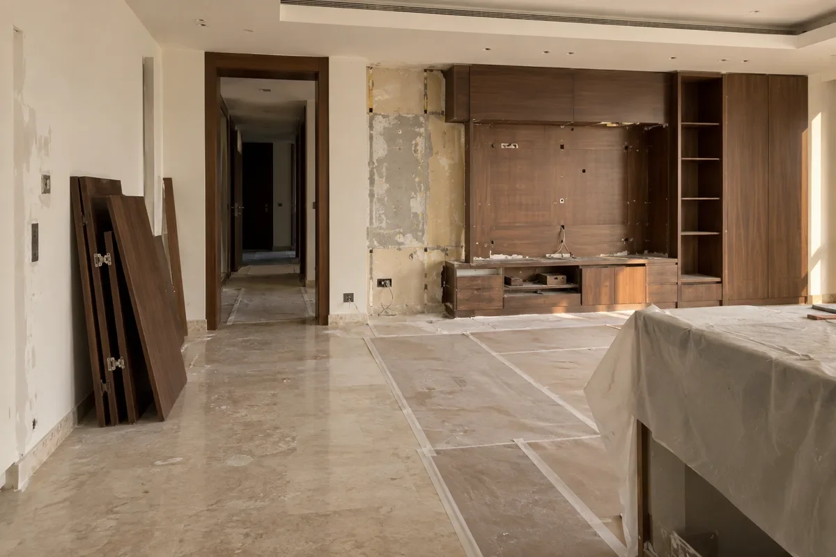 Resale penthouse living room with removed cabinetry and protected floors during renovation