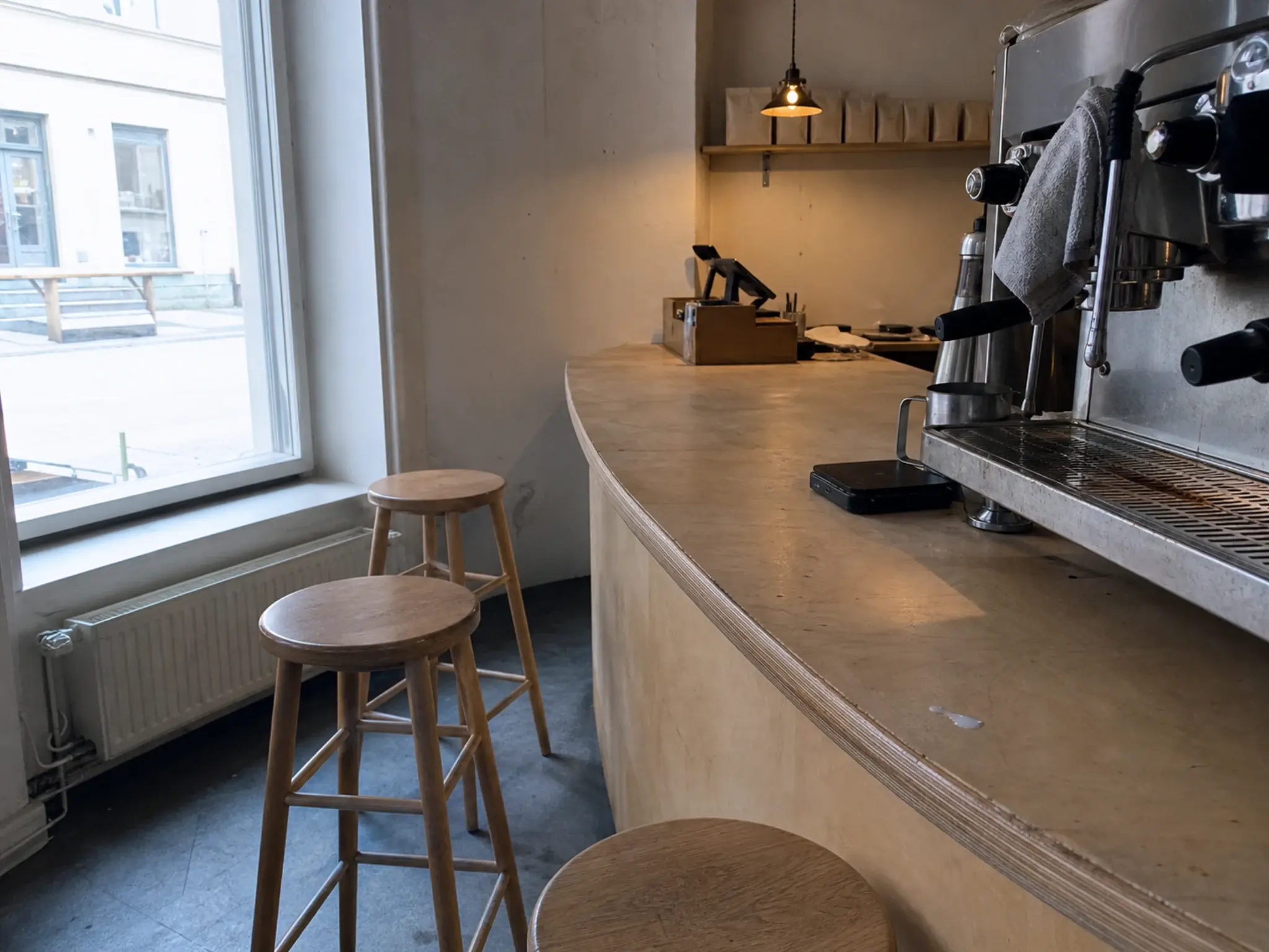 Scandinavian specialty coffee shop with birch plywood brew bar and white plastered walls