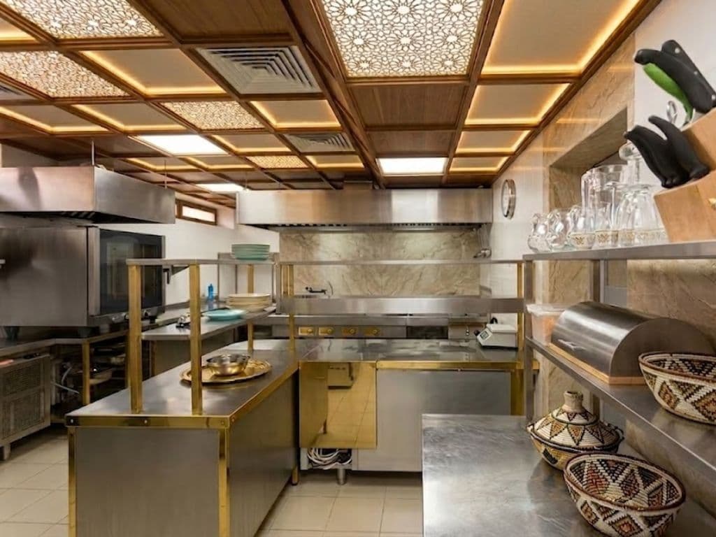 Commercial restaurant kitchen with stainless steel line and extraction canopy
