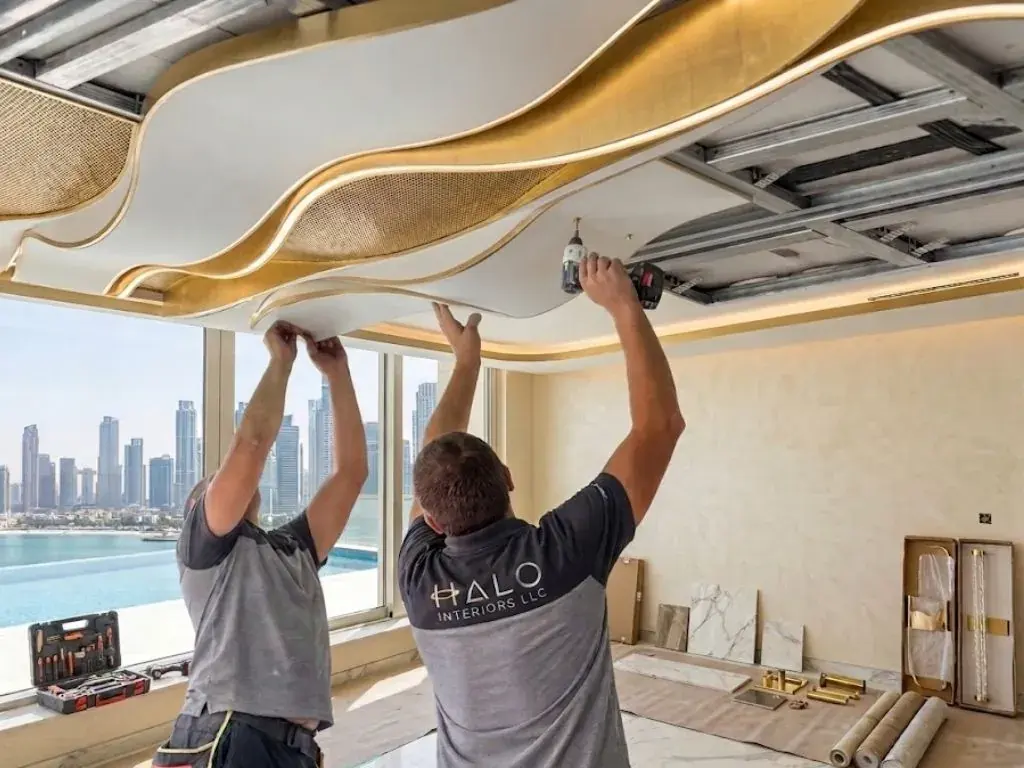 Two Halo installers tensioning a curved stretch ceiling membrane into place on a Dubai project
