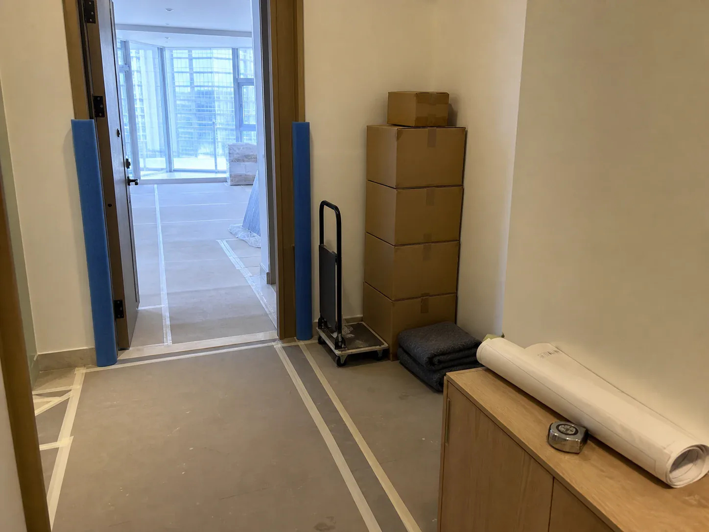 Protected apartment access route with project drawings, materials and delivery equipment during a Dubai tower renovation