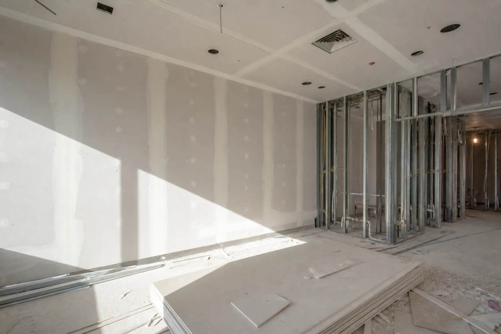 Metal-stud partitions part-boarded with ceiling openings already set out