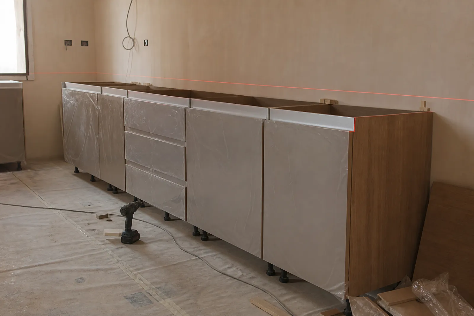 Joinery carcasses levelled and scribed against a cured plastered wall