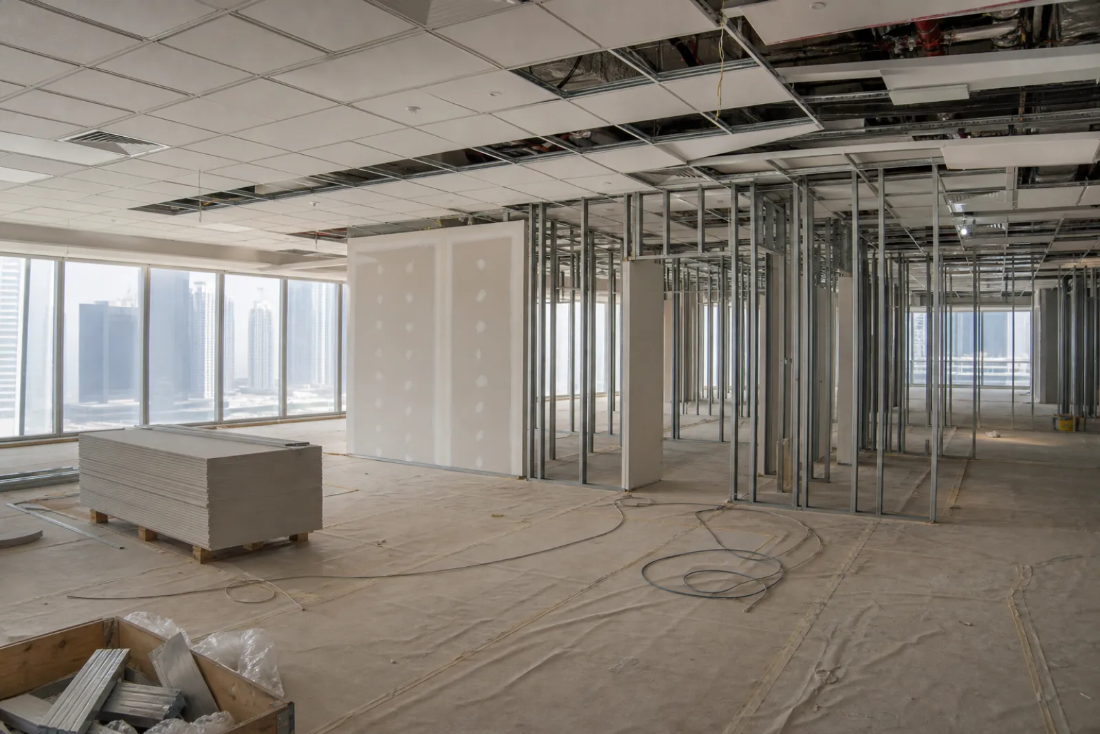 Dubai office floor plate mid-fit-out with partitions framed and ceiling grid part-installed