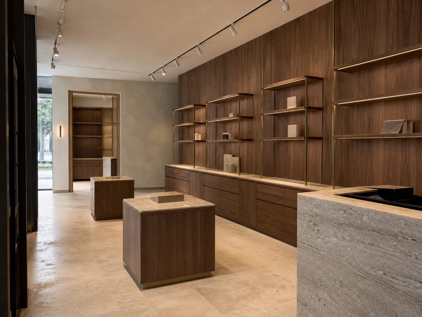 Empty premium retail interior with custom walnut display bays, stone counters and bespoke joinery